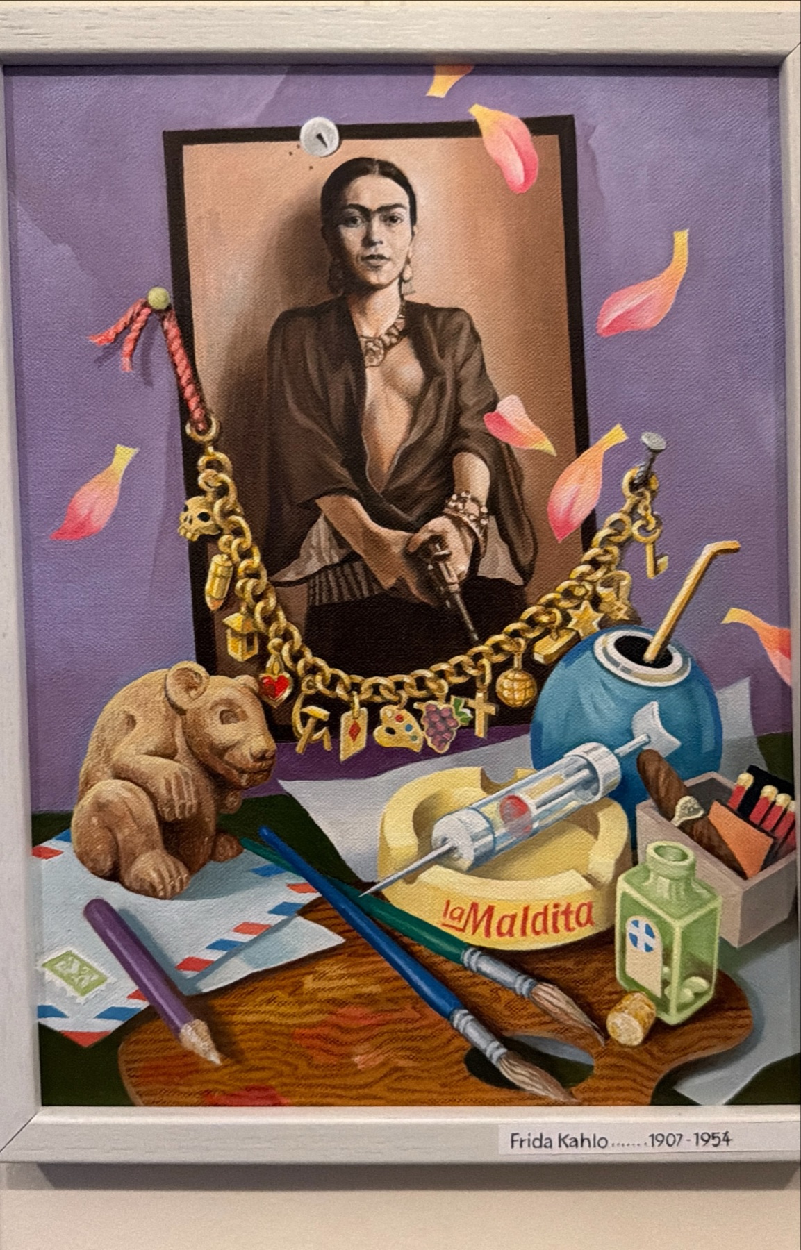 Frida Kahlo obklopená předměty a drobnými motivy.